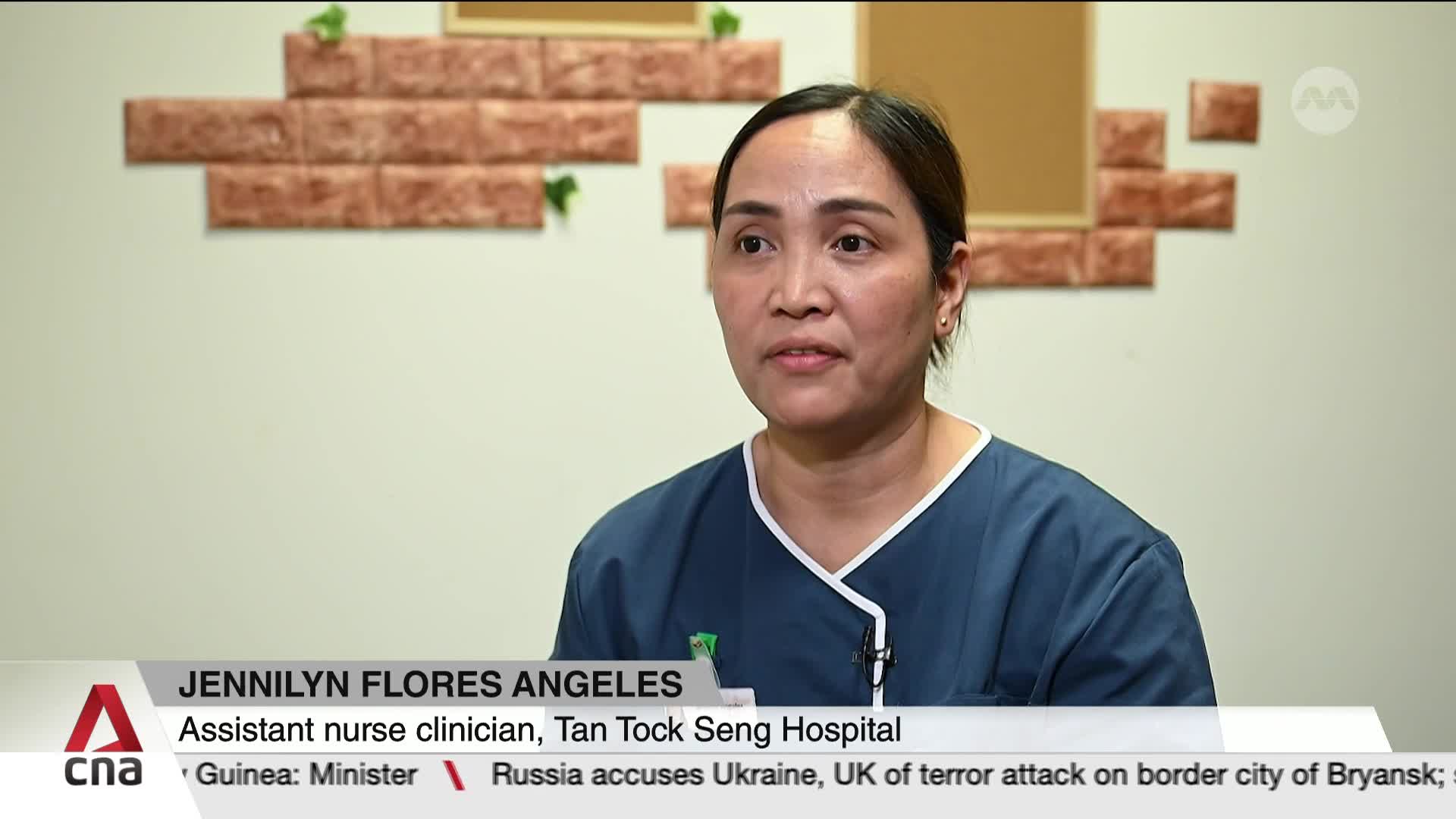 A woman in a blue scrub top speaks directly to the camera. Her name, Jennilyn Flores Angeles, and her role as an assistant nurse clinician at Tan Tock Seng Hospital in Singapore appear on screen.