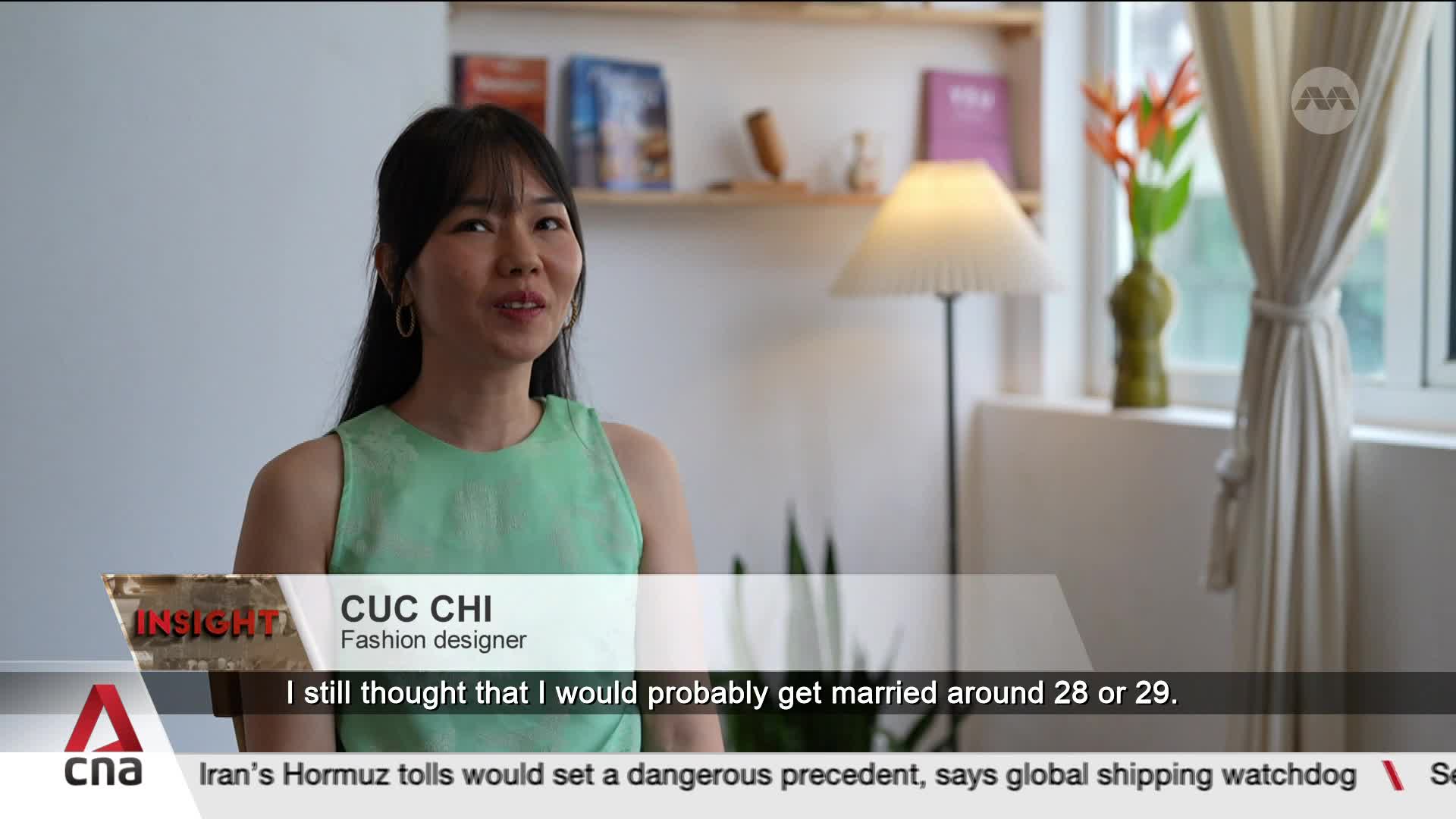 A woman in a light green top speaks, her dark hair framing her face. The CNA logo appears in the lower left corner, beneath a graphic identifying her as CUC CHI, Fashion designer.