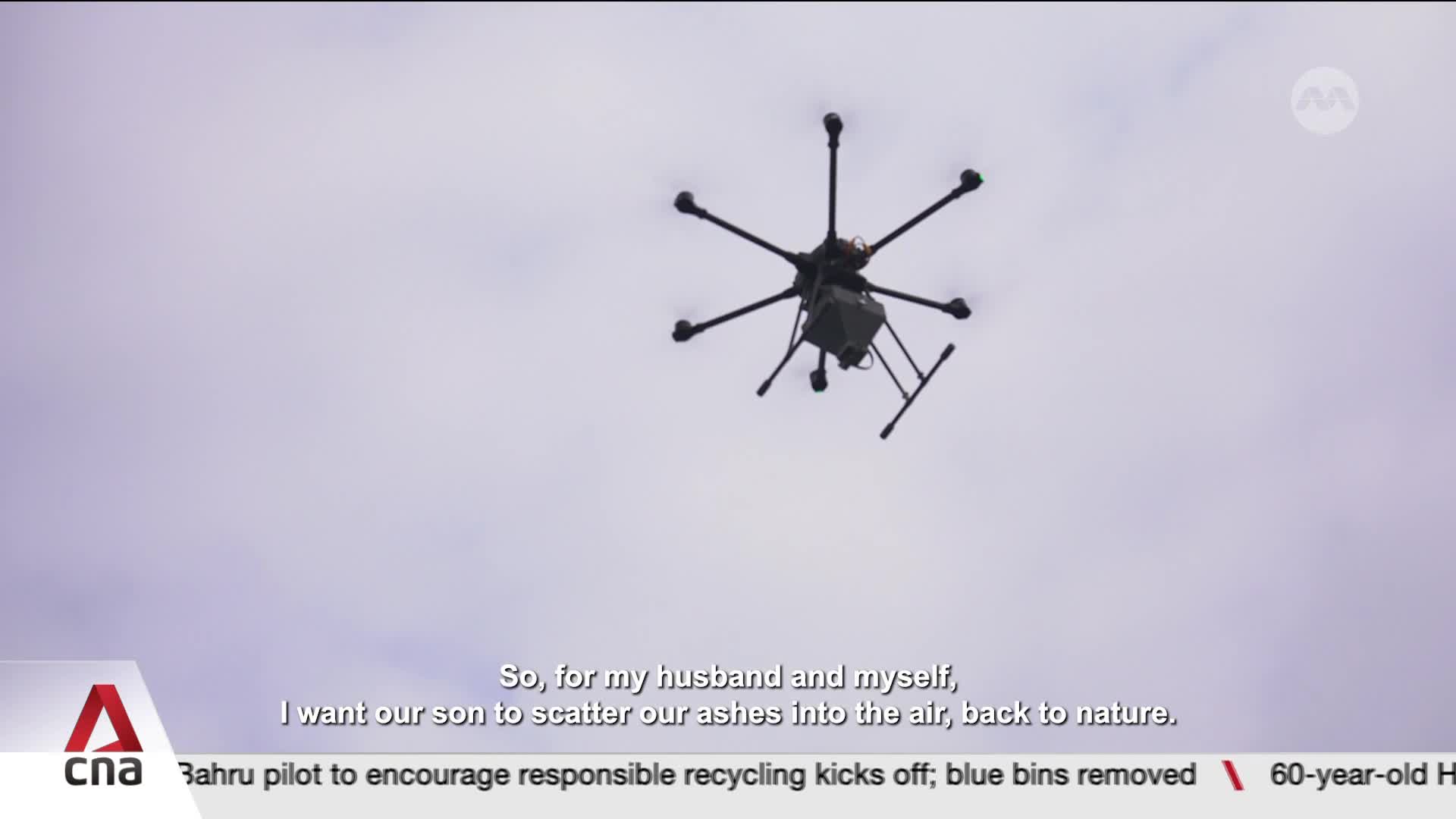 A hexacopter ascends into the pale sky, its rotors a steady hum. It carries a small, dark container, poised to release its contents.