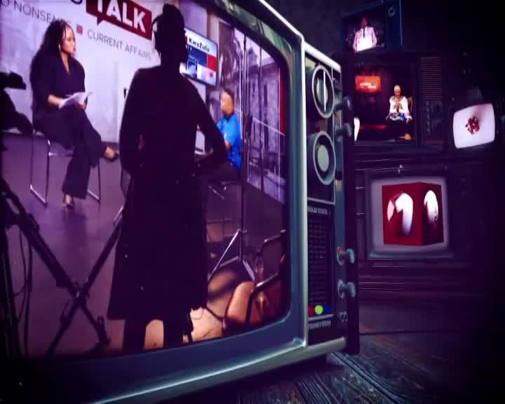 A silhouetted figure stands between me and a 1KZN TV set, reflecting the "No Nonsense Talk" set. Multiple vintage televisions are stacked around, each displaying a different segment.
A silhouetted figure stands between me and a 1KZN TV set, reflecting the "No Nonsense Talk" set. Multiple vintage televisions are stacked around, each displaying a different segment.