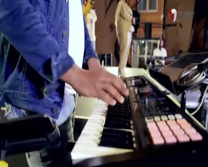 The musician's hands dance across the keys, a denim jacket framing the action. A 1KZN TV logo is visible, and the stage is set for a performance.
The musician's hands dance across the keys, a denim jacket framing the action. A 1KZN TV logo is visible, and the stage is set for a performance.