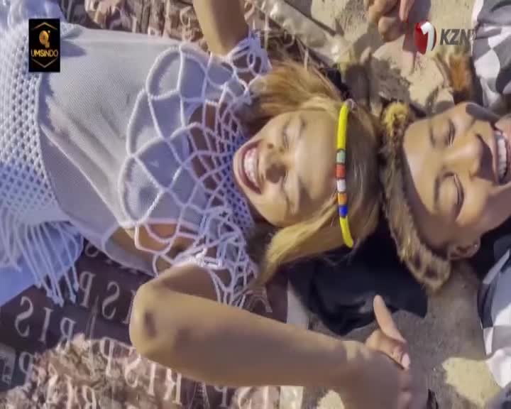 Two women lie on their backs, laughing, with their heads close together. A KZN TV watermark appears in the corner. Two women lie on their backs, laughing, with their heads close together. A KZN TV watermark appears in the corner.