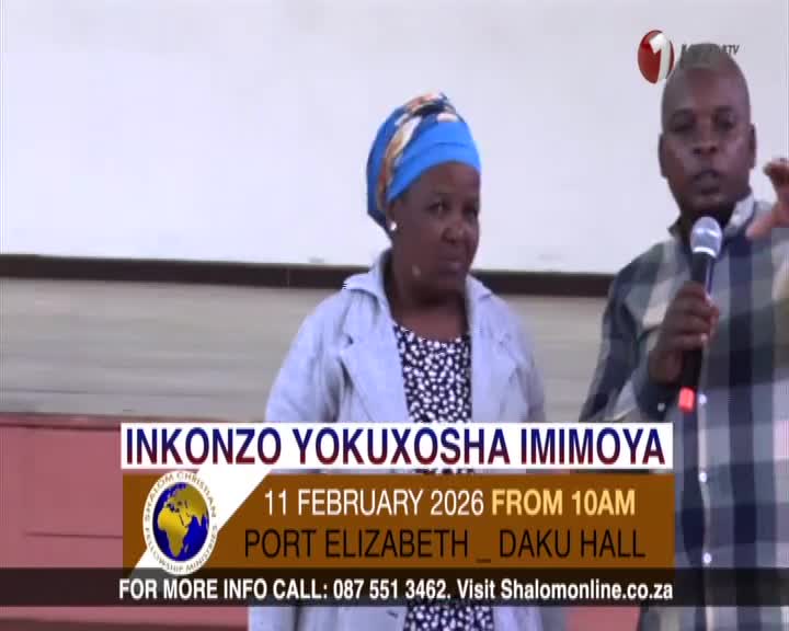 A man in a plaid shirt speaks into a microphone, gesturing with his free hand. Beside him, a woman in a blue headwrap and grey jacket watches intently. A banner below them announces "INKONZO YOKUXOSHA IMIMOYA" and details an event in Port Elizabeth on February 11, 2026. A man in a plaid shirt speaks into a microphone, gesturing with his free hand. Beside him, a woman in a blue headwrap and grey jacket watches intently. A banner below them announces "INKONZO YOKUXOSHA IMIMOYA" and details an event in Port Elizabeth on February 11, 2026.