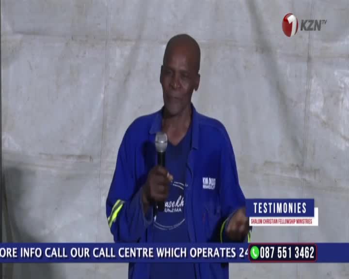 A man in a blue work shirt speaks into a microphone, his hands gesturing. A KZN TV logo is visible in the corner.