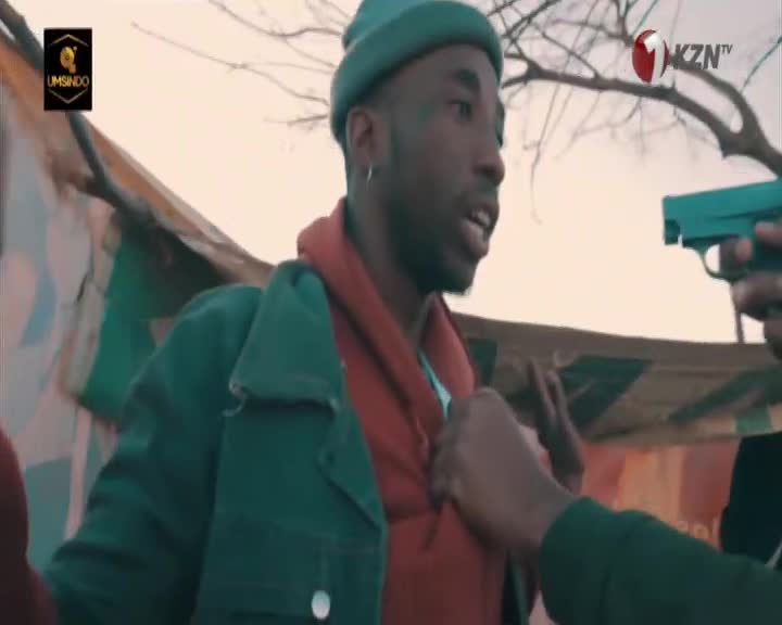 A gun is held to a man's chest, his hands raised in a defensive gesture. The KZNTV logo is visible in the corner of the screen.