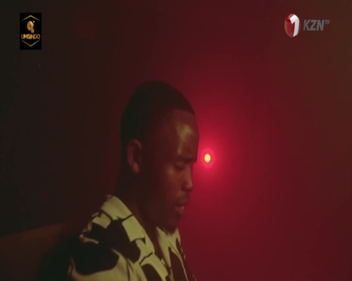 A man sits in the dim red light, his face turned down. The KZN TV logo is visible in the upper right corner.