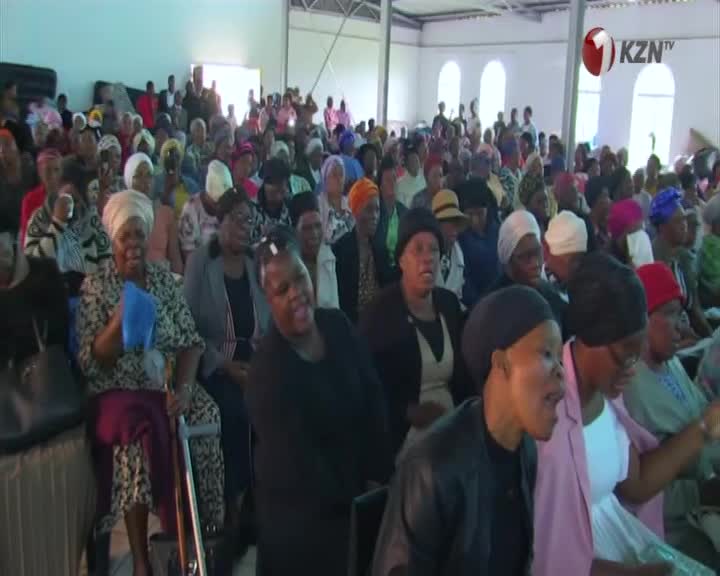 A large crowd fills the hall, many women wearing vibrant headscarves. The KZN TV logo is visible in the upper right corner.