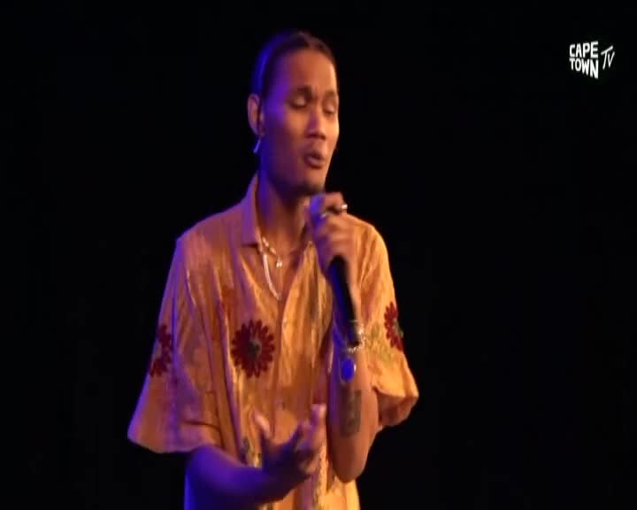 A man in a yellow floral shirt sings into a microphone, his eyes closed. The Cape Town TV logo is visible in the corner, indicating a live performance.

