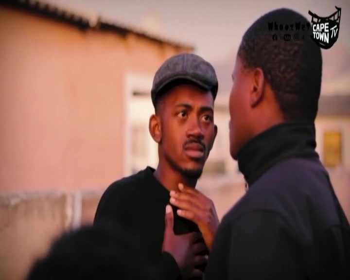 A man in a cap looks intently at another, his hand gesturing towards his chest. The Cape Town TV logo sits in the corner, as the scene unfolds in a South African setting.
