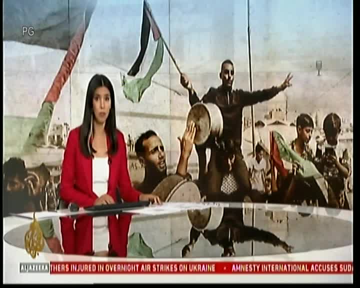 On Cape Town TV, a news anchor in a red jacket reports from a studio, while behind her, a black-and-white image shows people celebrating, some waving flags. The bottom of the screen displays news headlines from Al Jazeera.

