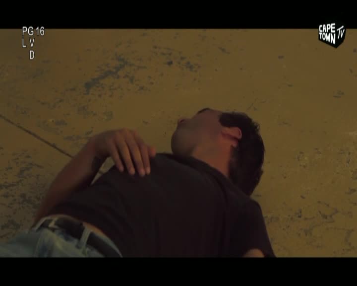 A man lies on his back, his head tilted back. His right arm rests across his chest, fingers splayed. The Cape Town TV logo is visible in the upper right corner.