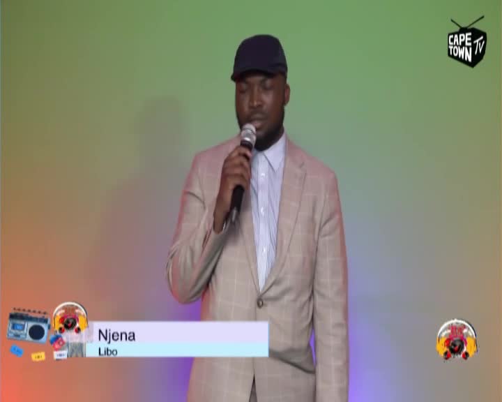 A man in a tan suit and a baseball cap holds a microphone, speaking into it. The Cape Town TV logo is visible in the upper right corner. A man in a tan suit and a baseball cap holds a microphone, speaking into it. The Cape Town TV logo is visible in the upper right corner.