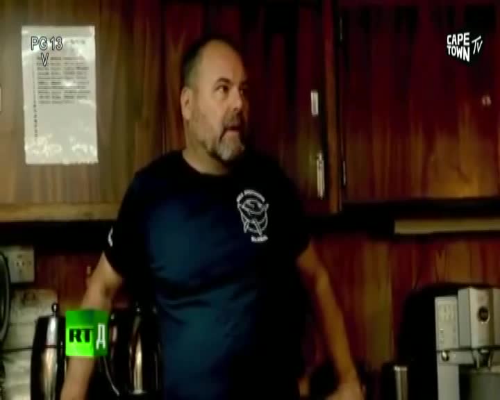 A man with a beard stands in a room with wooden cabinets. A "Cape Town TV" logo appears in the top right corner. A man with a beard stands in a room with wooden cabinets. A "Cape Town TV" logo appears in the top right corner.