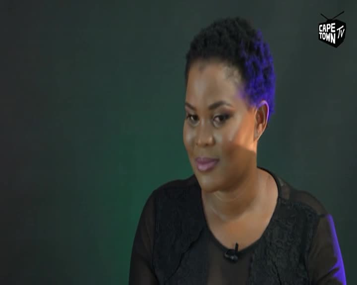 A woman with short, dark hair smiles slightly, her gaze directed off-camera. A subtle purple light catches the edge of her hair, and the Cape Town TV logo appears in the upper right corner.