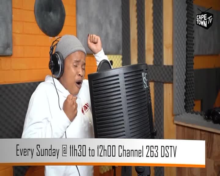 A performer, wearing headphones, belts into a microphone in a studio. The Cape Town TV logo is visible in the background.