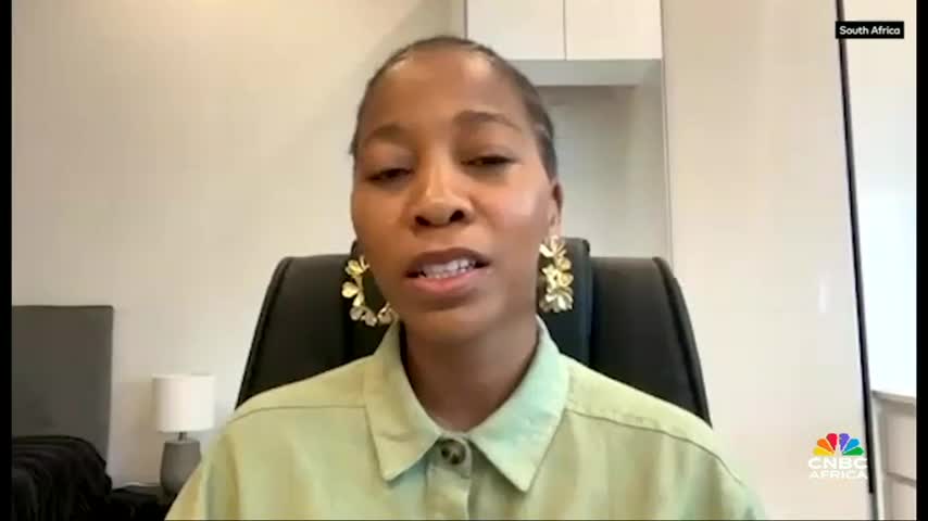 A woman in a light green shirt is speaking directly into the camera, her golden earrings catching the light. The CNBC Africa logo is visible, with "South Africa" displayed in the corner.
