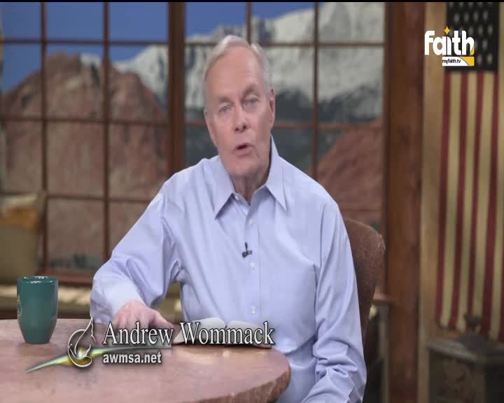 A man in a light blue shirt is speaking, his gaze directed toward the camera. The Faith TV logo is visible, and a small mug sits on the table beside him.
