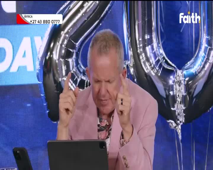 On Faith TV, a man in a pink jacket gestures with both index fingers raised, speaking intently. Behind him, giant silver balloons float, and the South Africa phone number is visible in the corner.
