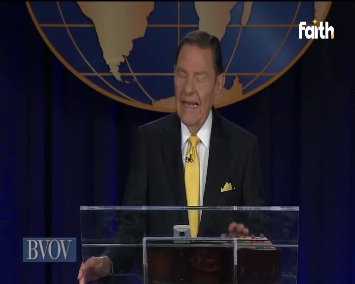 A man in a black suit and yellow tie is speaking passionately from behind a clear podium, with the Faith TV logo visible in the corner. Behind him, a large globe graphic dominates the background.
