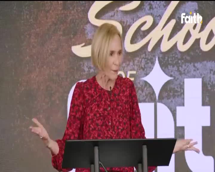 The woman in the red dress gestures with both hands, speaking from behind a podium. The Faith TV logo is visible in the background.
