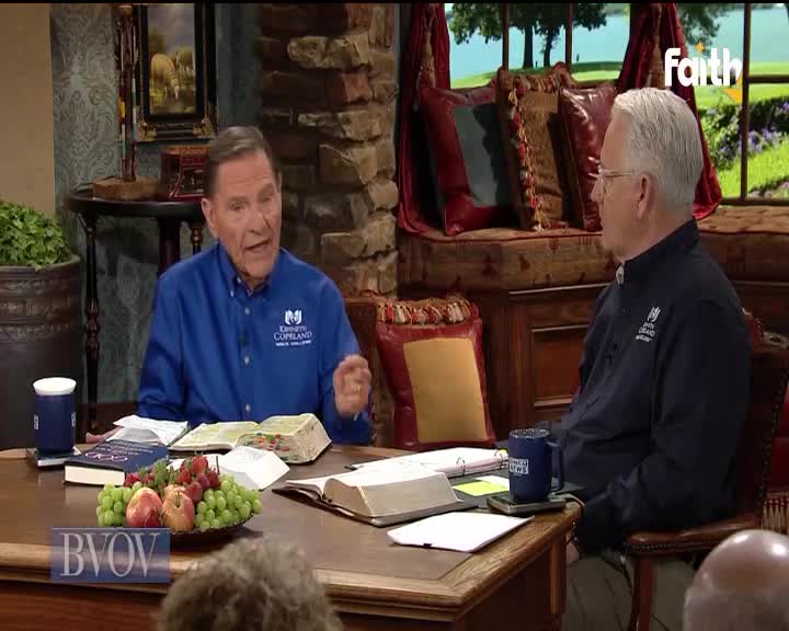 A man in a blue shirt gestures emphatically, speaking to another man seated across a wooden table. The scene is set for a broadcast on Faith TV, with BVOV branding visible.
