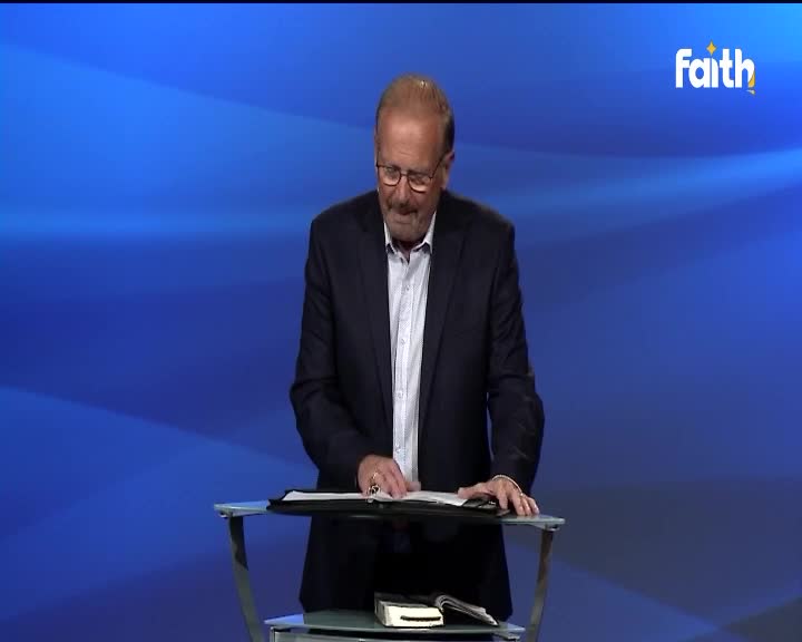A man in a dark suit, glasses perched on his nose, is standing at a lectern, turning the pages of a large book. The Faith TV logo is visible in the corner, and the backdrop is a gradient blue.
