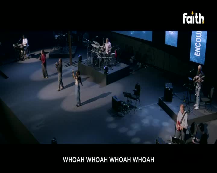 The band is on stage, with the drummer keeping the beat as the singers raise their hands. Below, the words "WHOAH" are displayed on the screen, a scene likely from Faith TV in South Africa.
