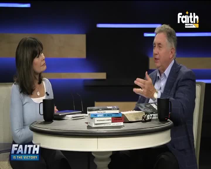 The man in the blazer gestures with his hands, speaking intently to the woman across the table. A Faith TV logo sits in the corner, and a stack of books and a Bible are on the table between them.
