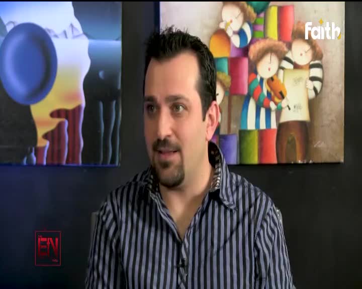 A man in a striped shirt speaks, with a colorful painting of children holding instruments behind him. The Faith TV logo appears in the upper right corner. A man in a striped shirt speaks, with a colorful painting of children holding instruments behind him. The Faith TV logo appears in the upper right corner.