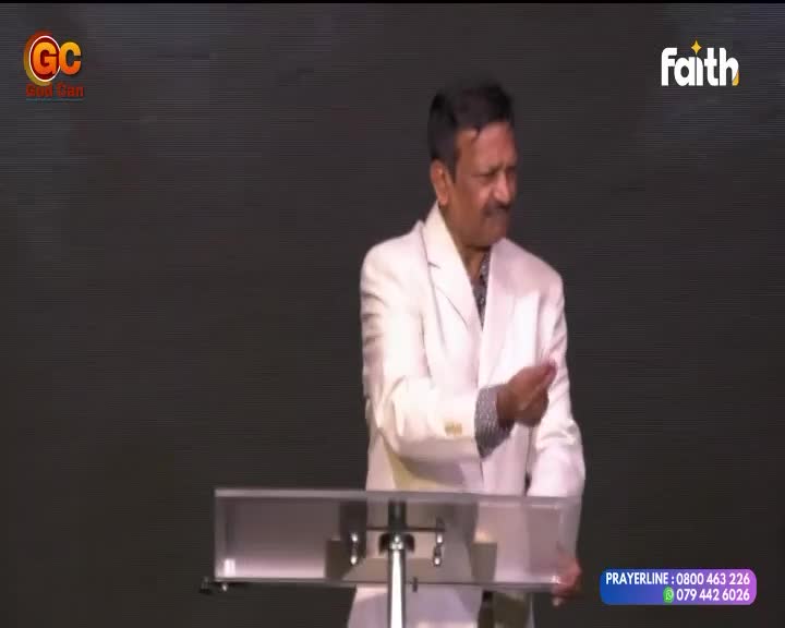 A man in a white suit gestures with his right hand, speaking from behind a clear lectern. The Faith TV logo appears in the upper right corner of the screen. A man in a white suit gestures with his right hand, speaking from behind a clear lectern. The Faith TV logo appears in the upper right corner of the screen.