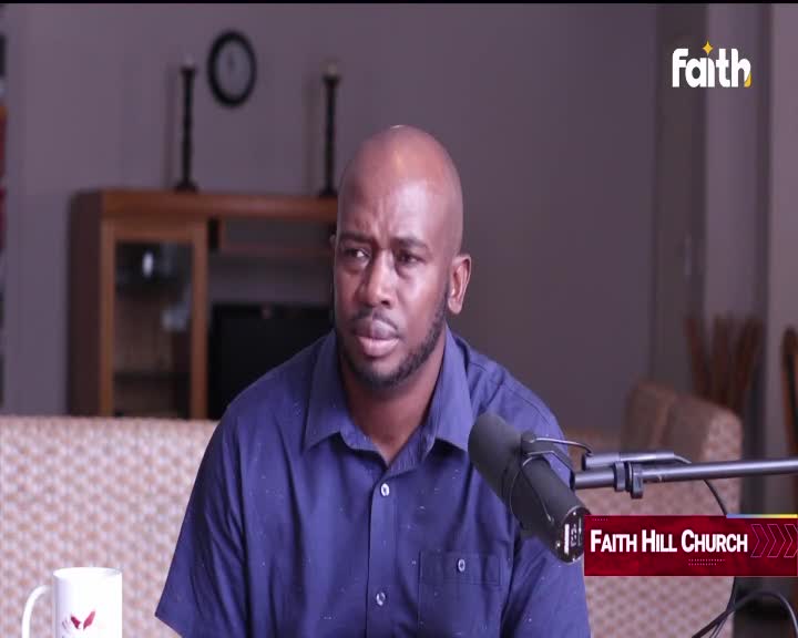 A man with a shaved head, wearing a blue collared shirt, speaks into a microphone. The Faith TV logo appears in the corner, indicating this broadcast originates from South Africa.