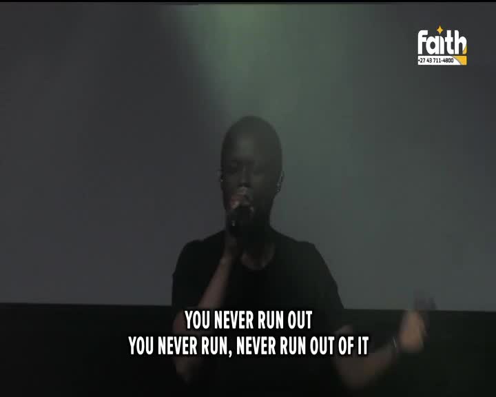 A man sings into a microphone on a stage, the words "YOU NEVER RUN OUT" appearing below him. This is a broadcast from Faith TV in South Africa.