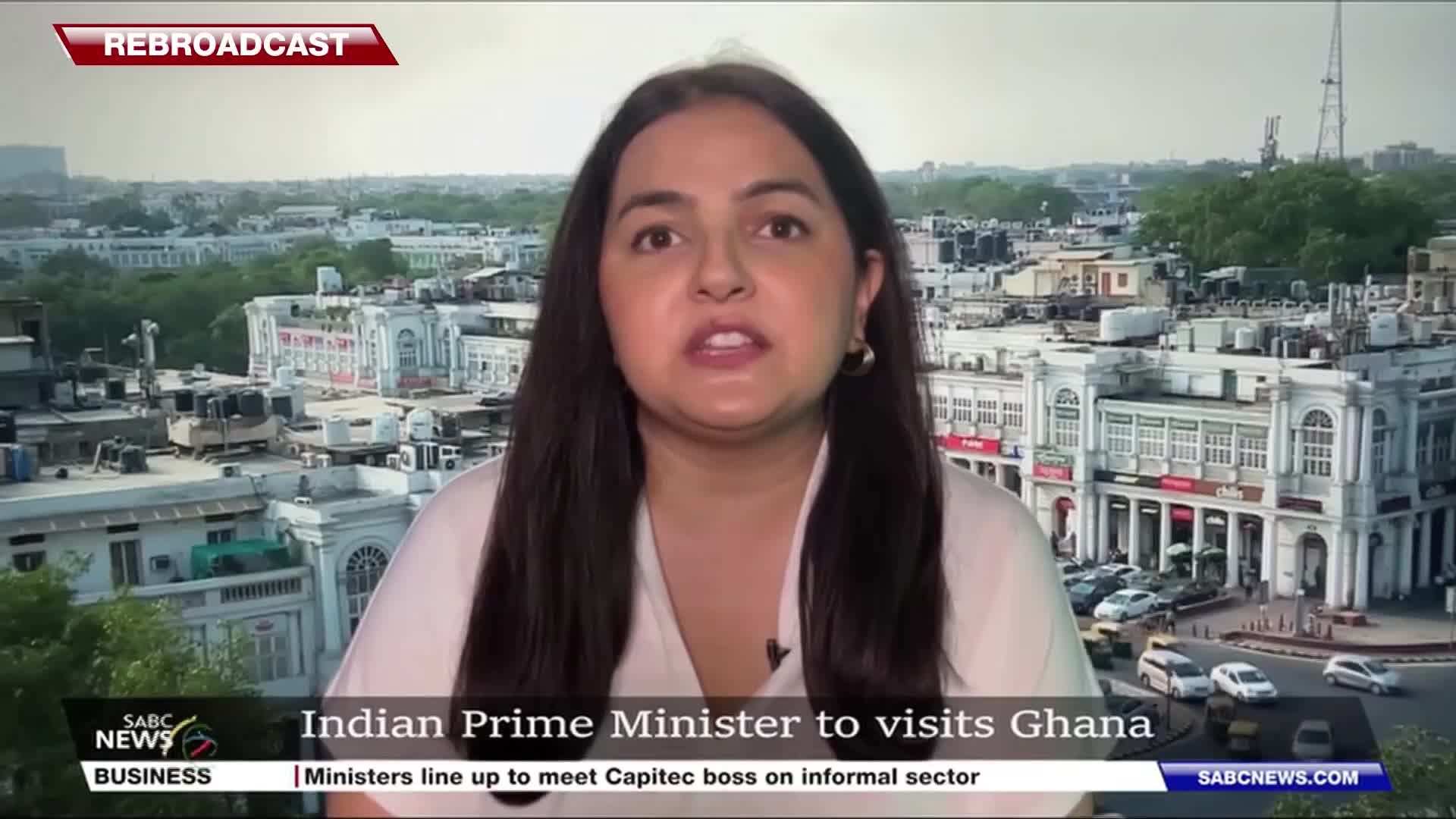 A woman with dark hair is speaking directly to the camera, framed against a cityscape. The SABC News logo and a lower third headline about the Indian Prime Minister's visit to Ghana are visible.
