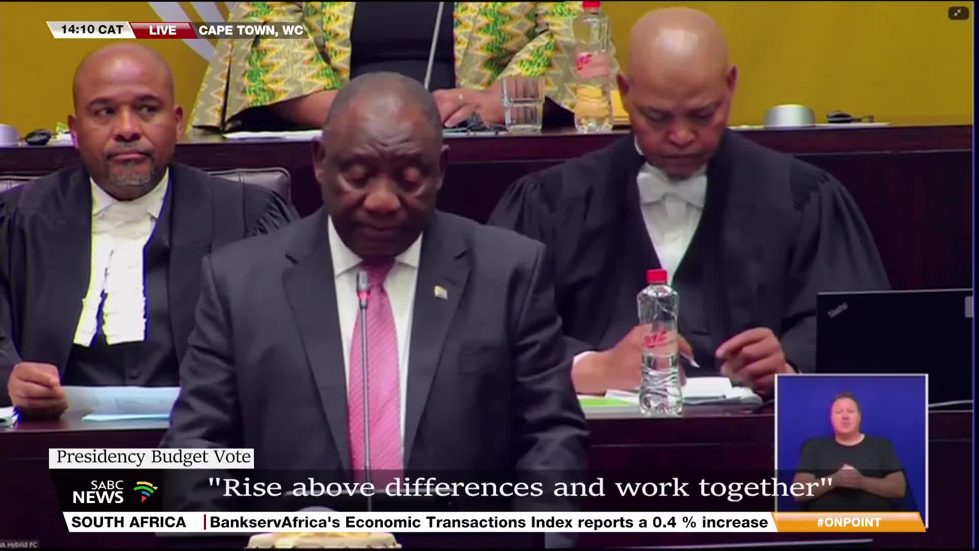 President Ramaphosa, in a dark suit and pink tie, is at the podium, speaking. SABC News is broadcasting live from Cape Town, with a sign language interpreter visible in the corner.
