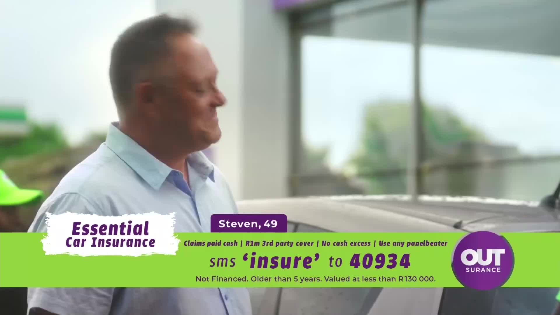 A man named Steven, 49, smiles as he stands near a car, probably at a petrol station. The ad for "Essential Car Insurance" and "Outsurance" flashes across the screen, reminding viewers to SMS "insure" to a number.
