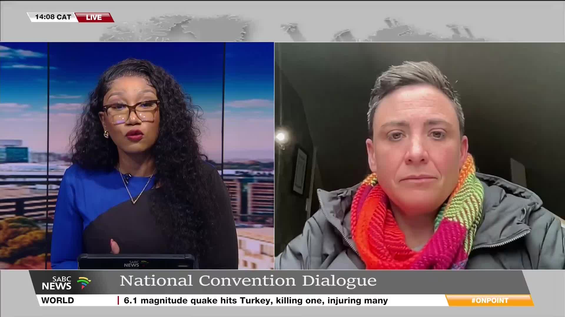 On SABC News, a presenter in a blue and black top is speaking live, while a person wearing a vibrant scarf appears on a split screen. The bottom of the screen displays information about a quake in Turkey.
