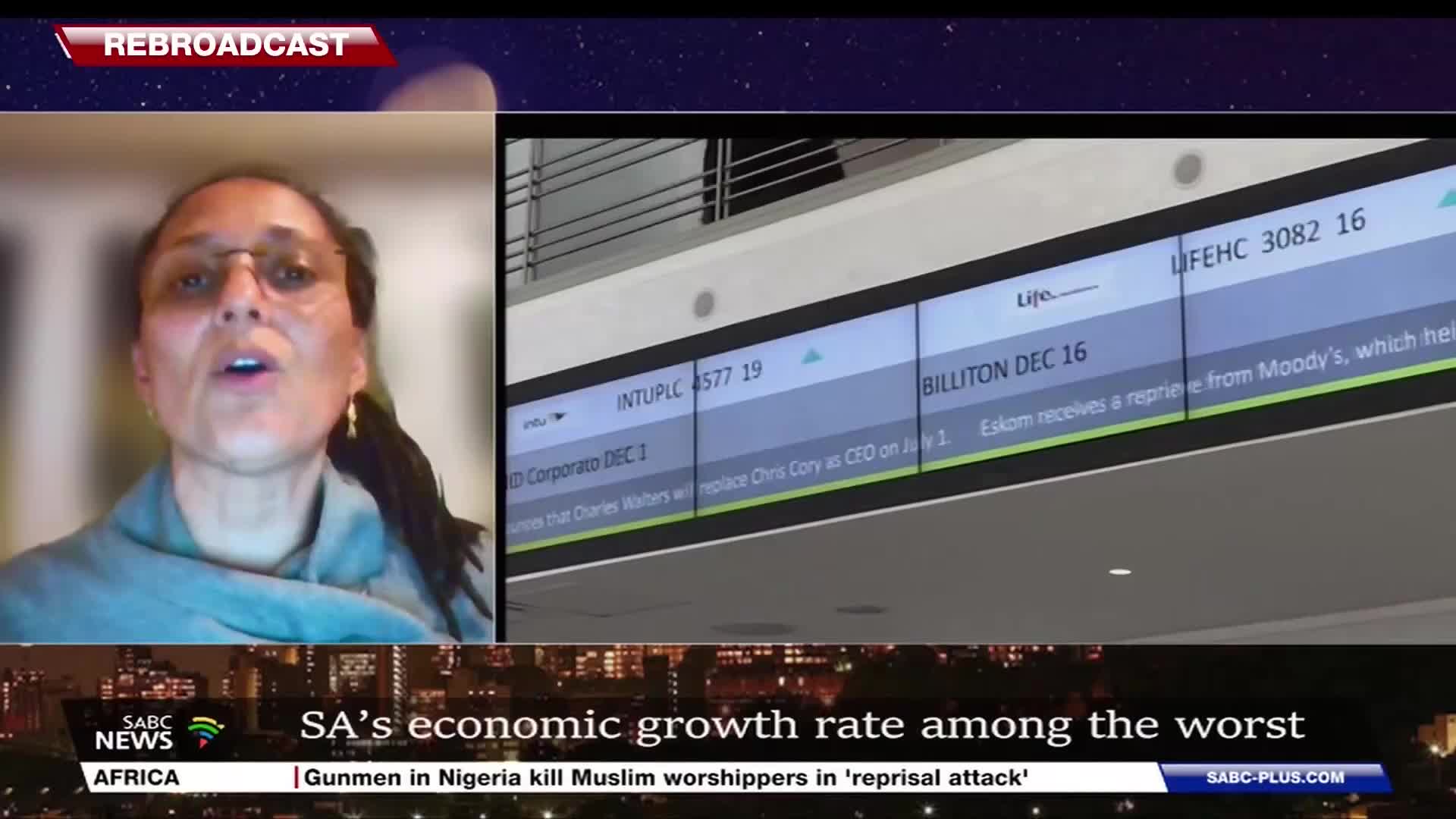 A woman with glasses speaks intently, her image framed by a screen showing stock market data. Below, the SABC News logo and a headline about South Africa's economic growth are visible.
