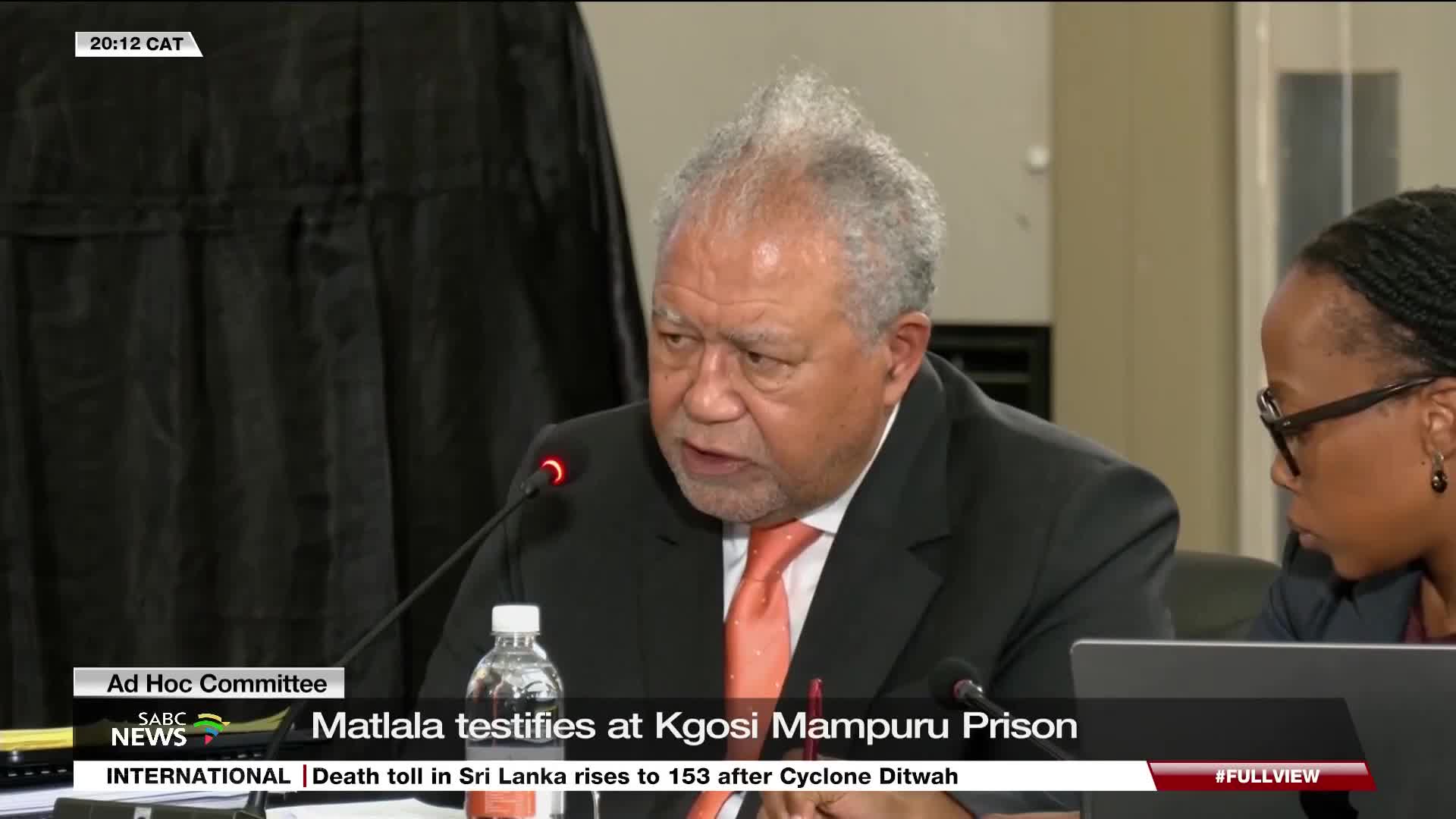 A man in a suit, with a prominent hairstyle, speaks into a microphone, his expression earnest. The SABC News graphic identifies the setting as a testimony at Kgosi Mampuru Prison.
A man in a suit, with a prominent hairstyle, speaks into a microphone, his expression earnest. The SABC News graphic identifies the setting as a testimony at Kgosi Mampuru Prison.