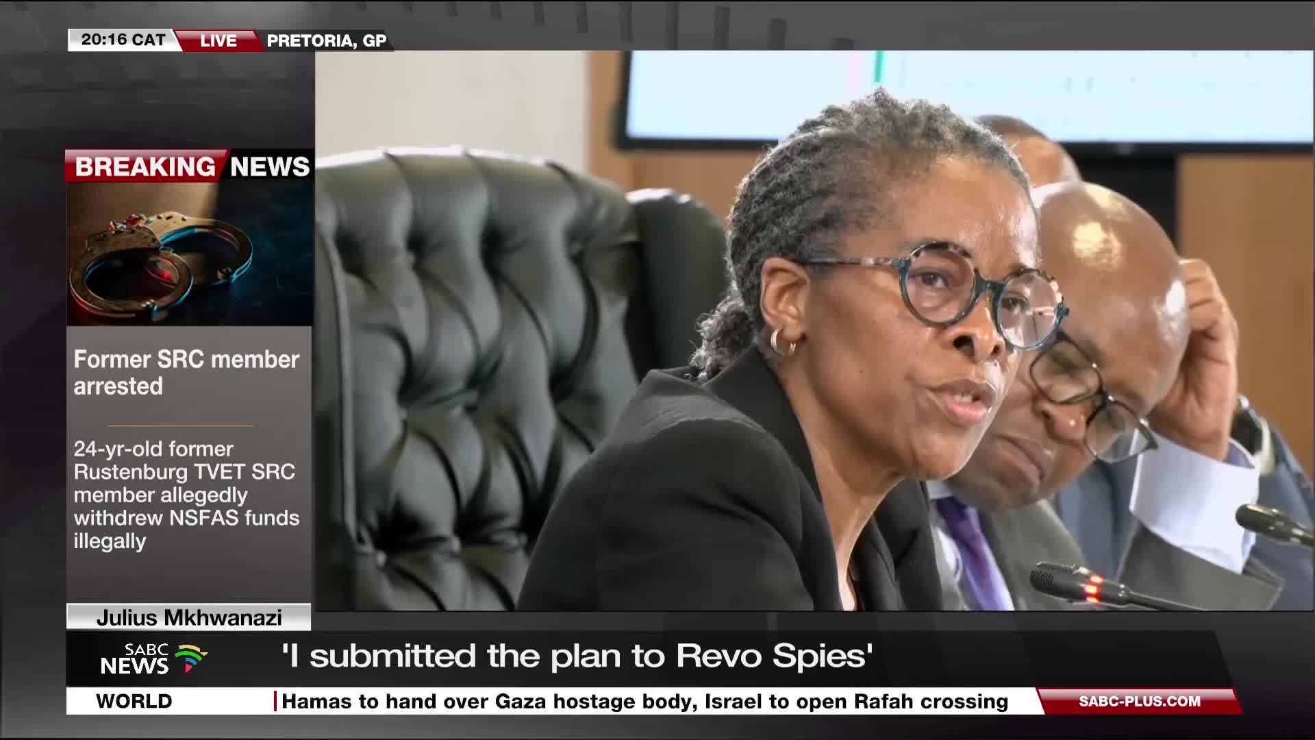 A woman with glasses speaks into a microphone, her mouth moving as she addresses the camera. The SABC News graphic at the bottom of the screen indicates the story is about a former SRC member.
A woman with glasses speaks into a microphone, her mouth moving as she addresses the camera. The SABC News graphic at the bottom of the screen indicates the story is about a former SRC member.