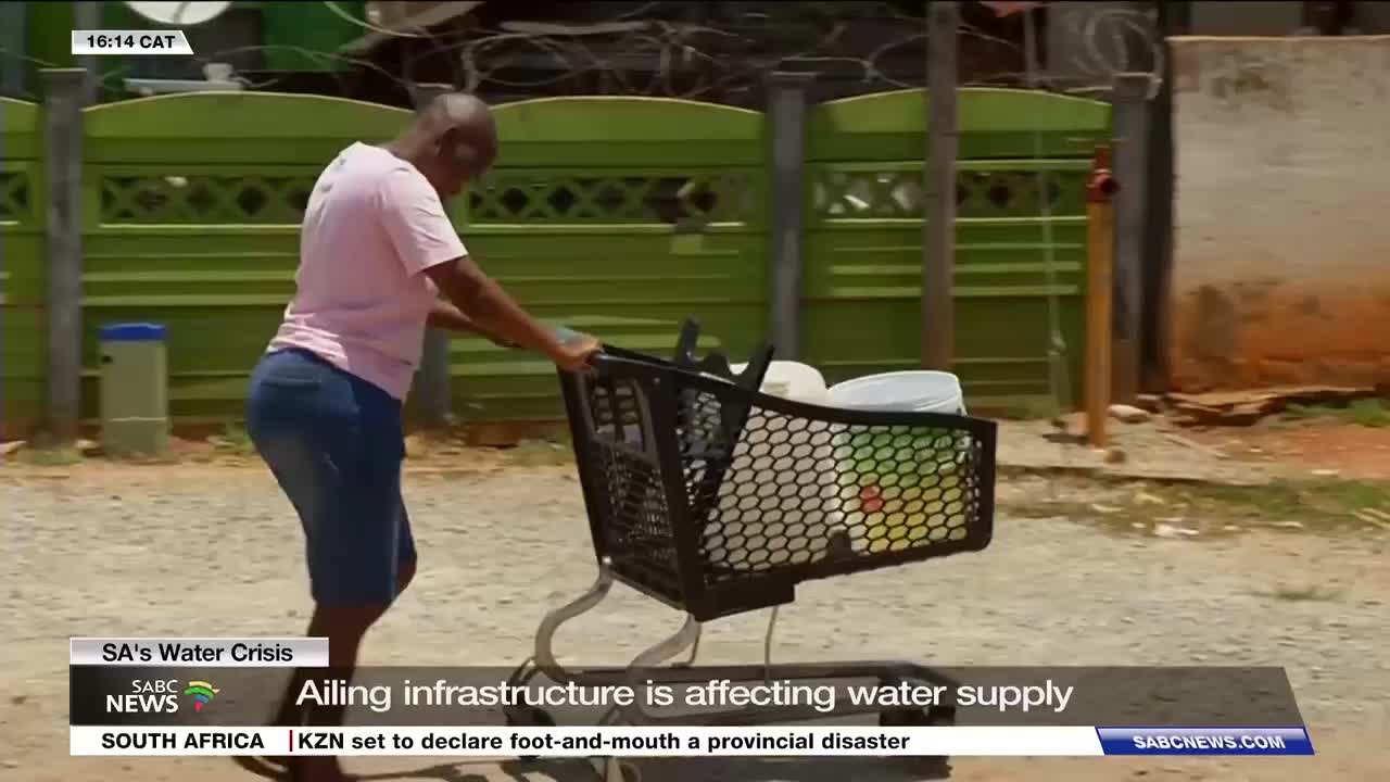 A woman pushes a shopping cart filled with buckets and containers down a dusty street. This scene, captured by SABC News, highlights the struggle for water in South Africa.