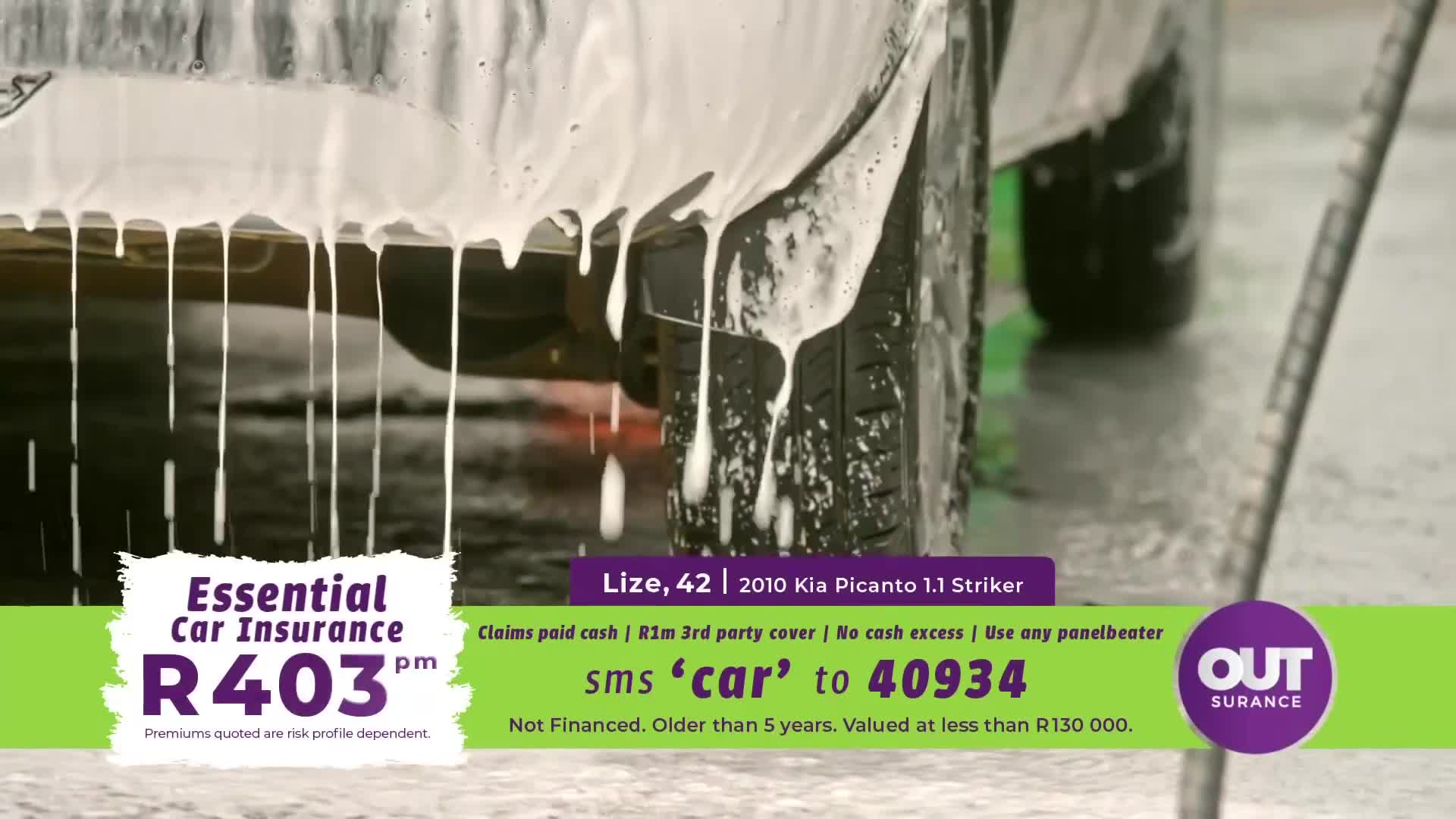 Thick white foam cascades down the side of a car, dripping onto the wet ground. A tire, still coated in suds, is visible as the vehicle is being washed. Thick white foam cascades down the side of a car, dripping onto the wet ground. A tire, still coated in suds, is visible as the vehicle is being washed.