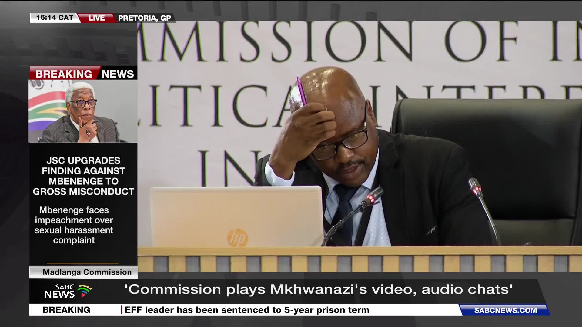 A man in a suit leans forward, his hand on his forehead, a pink pen clutched in his fingers. The SABC News chyron announces "Commission plays Mkhwanazi's video, audio chats."