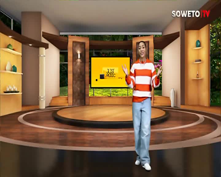 A woman in a striped shirt and jeans gestures with both hands on the Soweto TV set. Behind her, a screen displays "Just Music."
