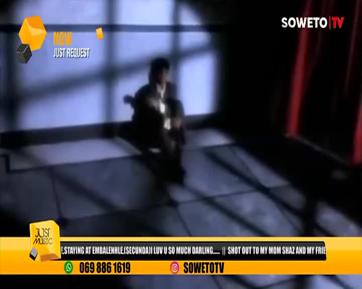 A figure, silhouetted against the light, is seated and playing a guitar on the Soweto TV music show. The "Just Request" graphic is on the screen, along with a shout-out to family and friends.
