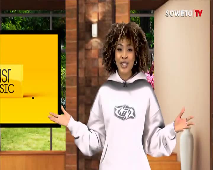 The woman on Soweto TV gestures with open hands, facing the camera. Behind her, a bright yellow screen displays the words "IST MUSIC."
