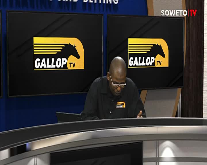 The man in glasses, wearing a black shirt, leans over a desk, his hands gesturing. Behind him, two screens on Soweto TV display the "Gallop TV" logo.
