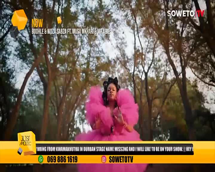 A woman in a bright pink dress stands in front of a tree-lined backdrop, appearing on Soweto TV. The screen displays the names of the artists and a phone number.
