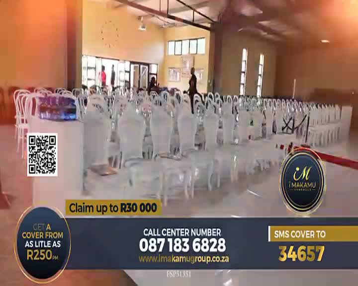 Rows of chairs, some with white covers, fill a large hall, likely for an event. The bottom of the screen displays a commercial for insurance, with contact information and a QR code.
