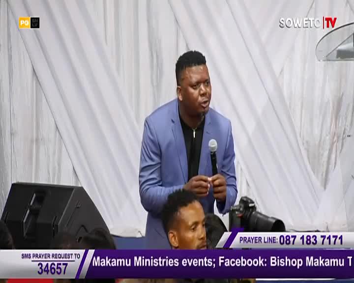 A man in a blue blazer speaks into a microphone, his expression intense, as he addresses the crowd. The Soweto TV logo is visible, and the screen displays information for prayer requests.
