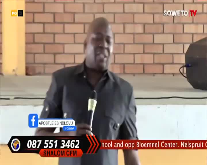 A man in a dark shirt speaks into a microphone, his gestures animated as he addresses the camera. The Soweto TV logo is visible, and contact information for Shalom CFM is displayed below.
